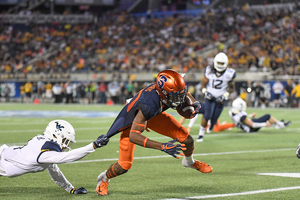 Taj Harris keeps running through a tackle in Syracuse's win.