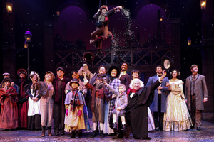 An acrobat hangs from above throwing fake snow as performers prepare to leave the stage. The Syracuse Stage is performing “A Christmas Carol” until Dec. 31.