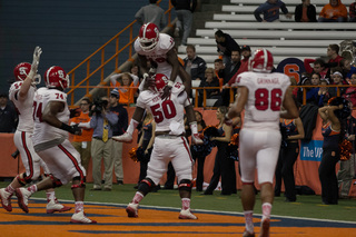 N.C. State's Shadrach Thornton celebrates his victory-clinching touchdown in the fourth quarter with center Tony Adams and other Wolfpack teammates.