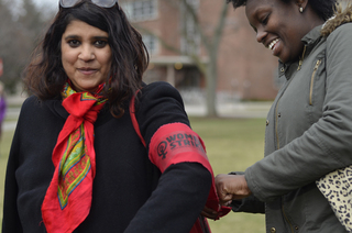 Shanique Mothersill (right) helps 
Himika B. (left) tie her red 