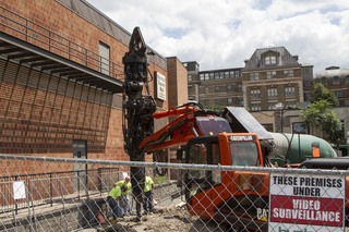 Construction crews watch as a hole is drilled into the ground at the former home of Hungry Chuck's and Funk 'n Waffles as a multistory student housing project is being built in its place. Photo taken July 11, 2017