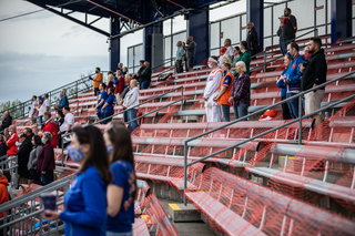 Fans watch the game from the stands, where they are spaced out into pods that are 6 feet apart.