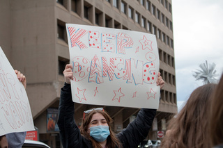 Students hold up signs encouraging dancers to keep going on their way to the children’s hospital.